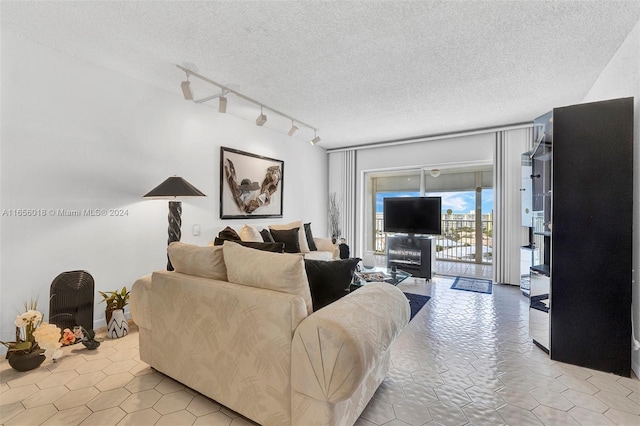 living room featuring a textured ceiling, rail lighting, and light tile patterned floors