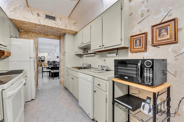 kitchen featuring a textured ceiling, white cabinets, sink, and white appliances