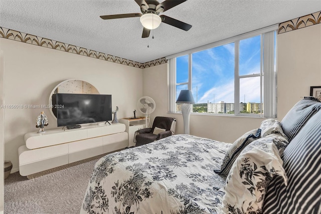 bedroom with a textured ceiling, carpet flooring, and ceiling fan