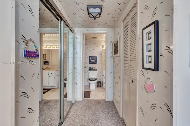 hallway with light carpet and sink