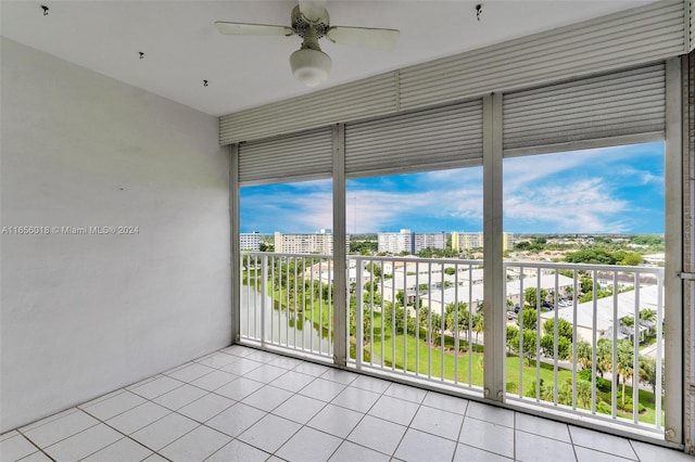 empty room featuring light tile patterned floors, a wealth of natural light, and ceiling fan