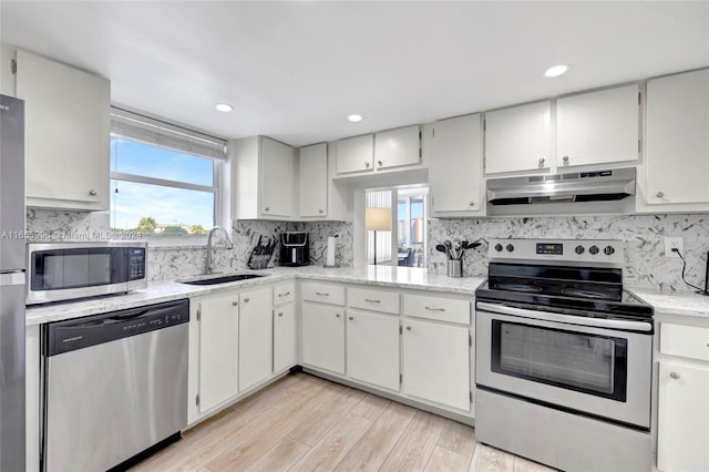 kitchen with white cabinetry, stainless steel appliances, sink, and light hardwood / wood-style floors