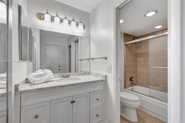 full bathroom with tile patterned floors, vanity, toilet, and combined bath / shower with glass door