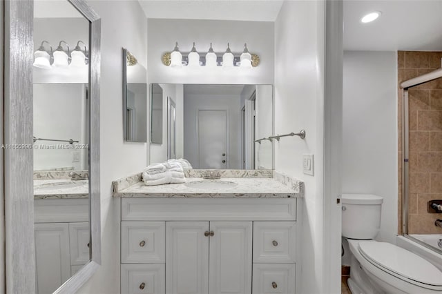 full bathroom featuring shower / bath combination with glass door, vanity, and toilet