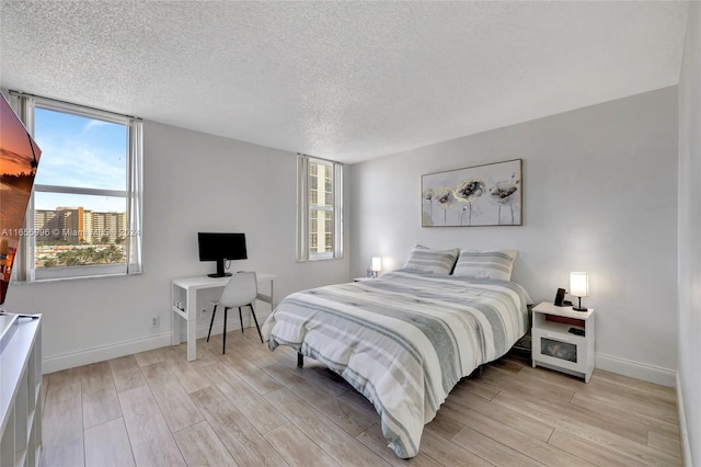 bedroom featuring light hardwood / wood-style floors and a textured ceiling