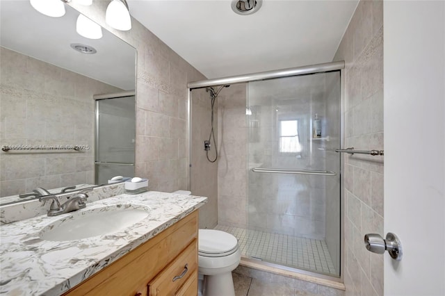full bathroom with toilet, tile walls, a shower stall, and vanity
