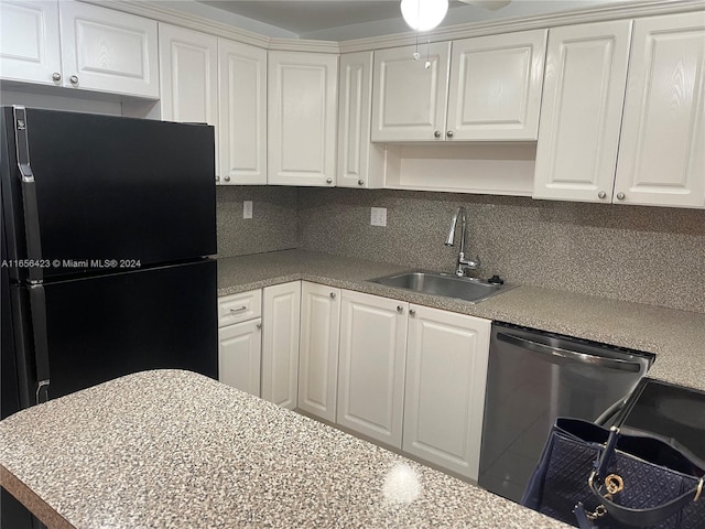 kitchen featuring ceiling fan, black refrigerator, white cabinetry, and sink