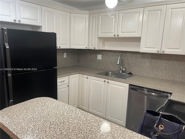 kitchen featuring stainless steel dishwasher, tasteful backsplash, freestanding refrigerator, and a sink