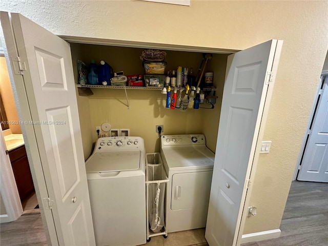 clothes washing area with separate washer and dryer and hardwood / wood-style flooring