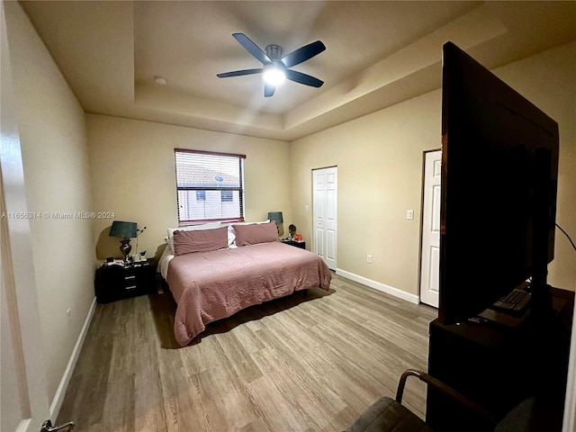 bedroom featuring a tray ceiling, hardwood / wood-style flooring, and ceiling fan