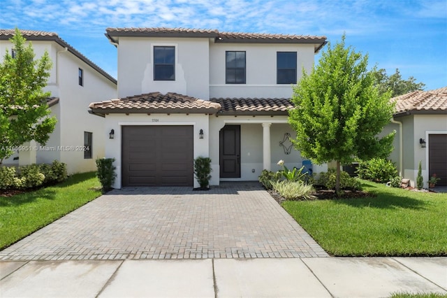 mediterranean / spanish-style home featuring a garage and a front yard