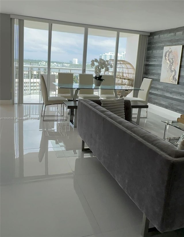 living room with baseboards, floor to ceiling windows, and a view of city
