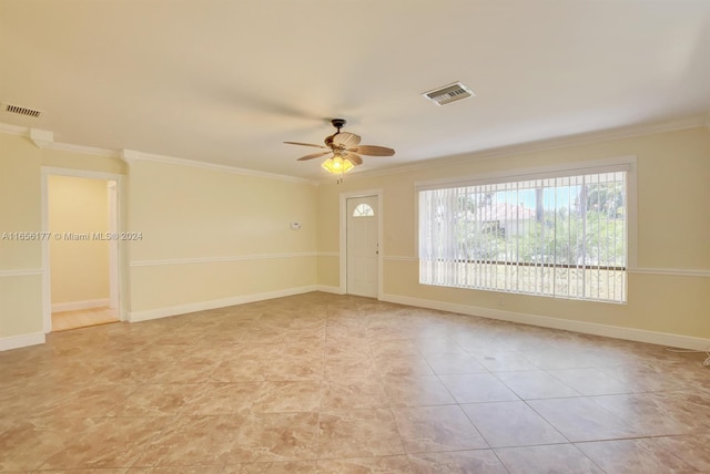 empty room featuring ceiling fan and ornamental molding