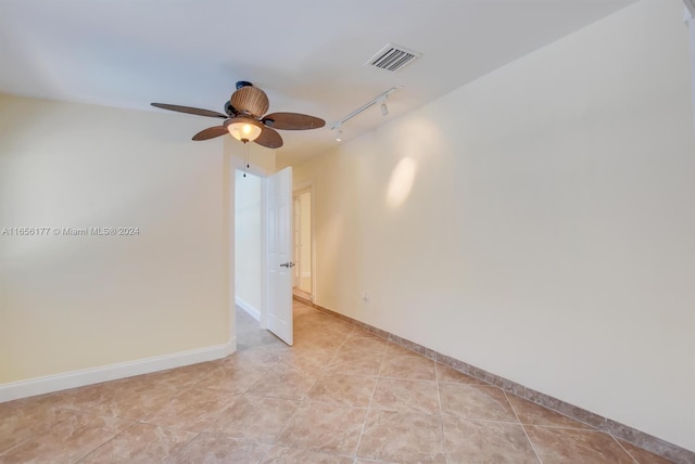 empty room with rail lighting, light tile patterned flooring, and ceiling fan