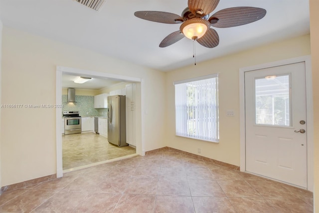 tiled entryway featuring ceiling fan