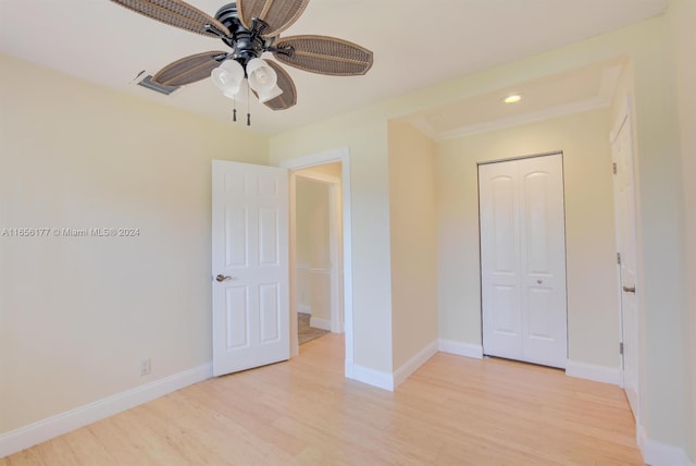 unfurnished bedroom featuring light hardwood / wood-style flooring, ceiling fan, and a closet