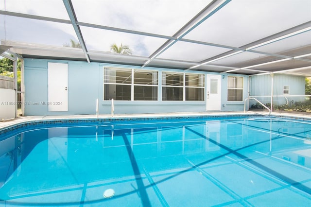 view of swimming pool featuring glass enclosure