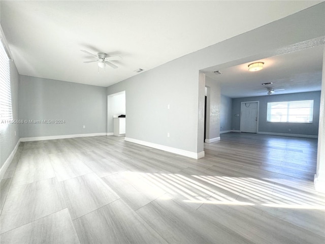 empty room with ceiling fan and light wood-type flooring