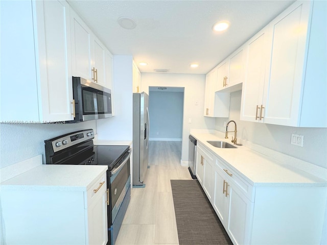 kitchen featuring stainless steel appliances, sink, and white cabinets