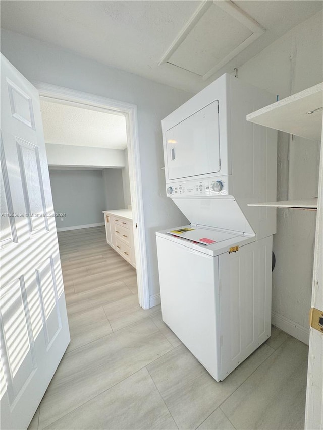 laundry area featuring light hardwood / wood-style flooring and stacked washer and clothes dryer