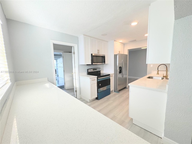 kitchen featuring white cabinetry, a healthy amount of sunlight, stainless steel appliances, and sink