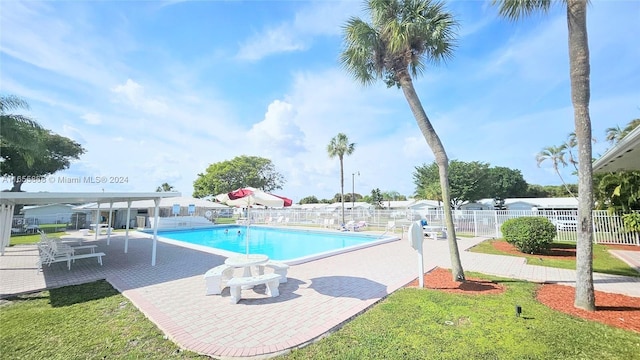 view of swimming pool with a yard and a patio area