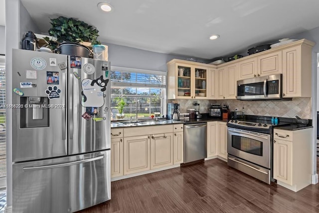 kitchen with backsplash, cream cabinets, dark hardwood / wood-style floors, and stainless steel appliances