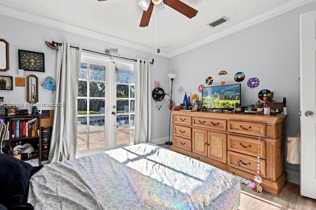 bedroom featuring a textured ceiling, access to exterior, light hardwood / wood-style flooring, ornamental molding, and ceiling fan