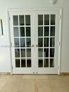 doorway with french doors and light tile patterned floors