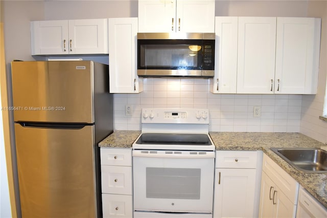 kitchen with light stone counters, backsplash, stainless steel appliances, and white cabinets