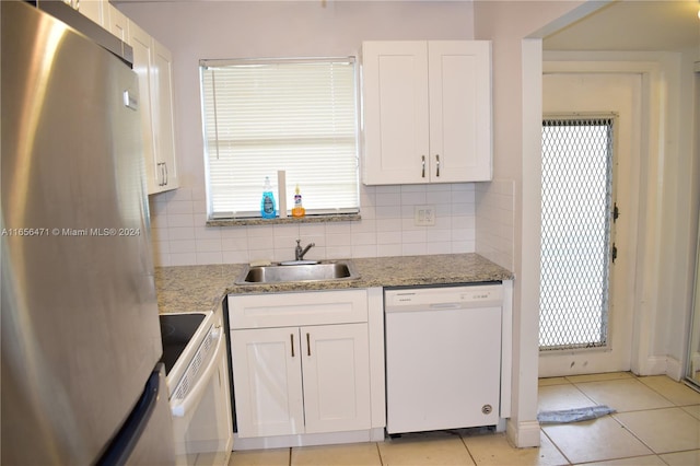 kitchen featuring white appliances, light stone countertops, white cabinetry, and a healthy amount of sunlight