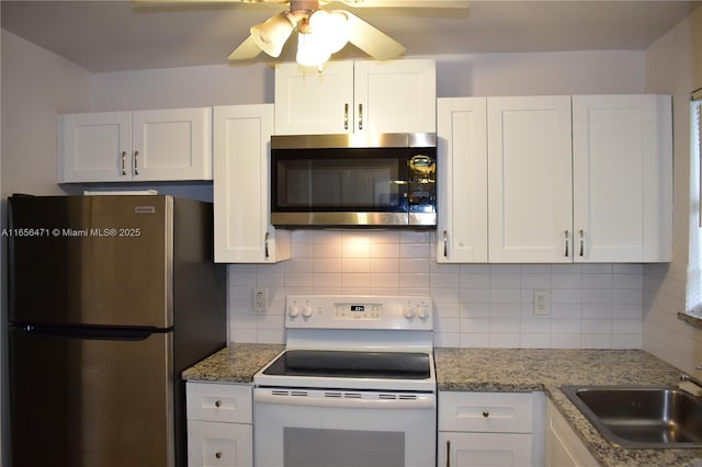 kitchen featuring a ceiling fan, backsplash, white cabinets, and stainless steel appliances