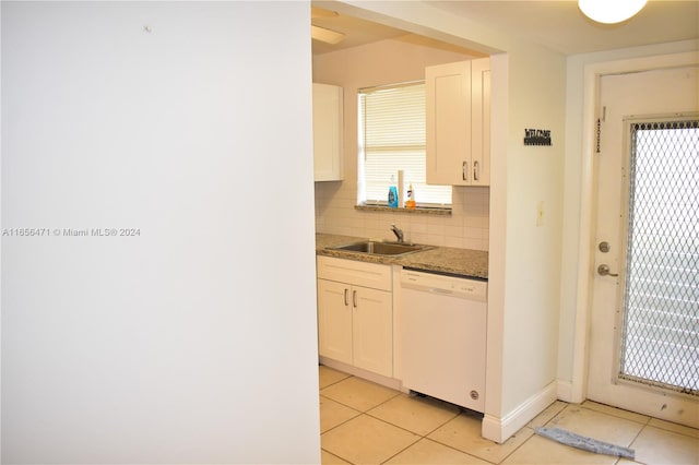 kitchen featuring white cabinets, backsplash, white dishwasher, light tile patterned floors, and sink