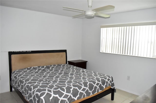 bedroom featuring tile patterned flooring, a ceiling fan, and baseboards