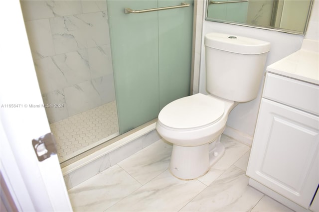 bathroom featuring tiled shower, toilet, and vanity