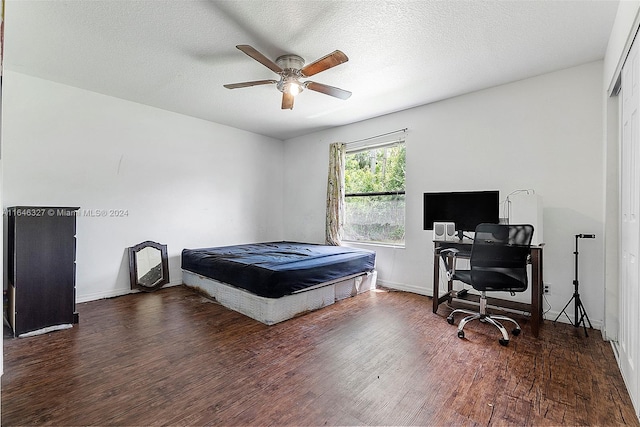 bedroom featuring a textured ceiling, ceiling fan, and dark hardwood / wood-style floors