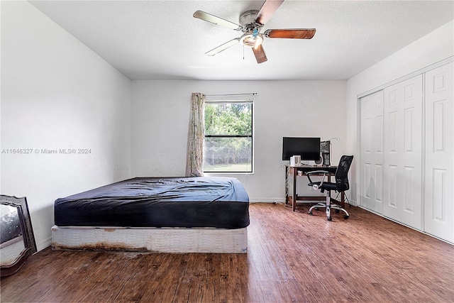 bedroom featuring a closet, ceiling fan, hardwood / wood-style flooring, and a textured ceiling