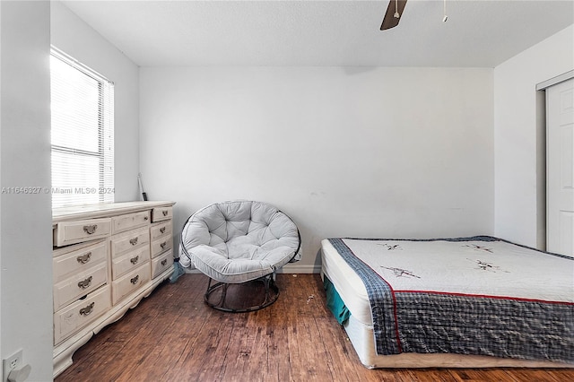 bedroom featuring dark hardwood / wood-style flooring, ceiling fan, and a textured ceiling