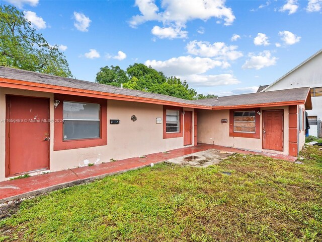 rear view of property featuring a yard