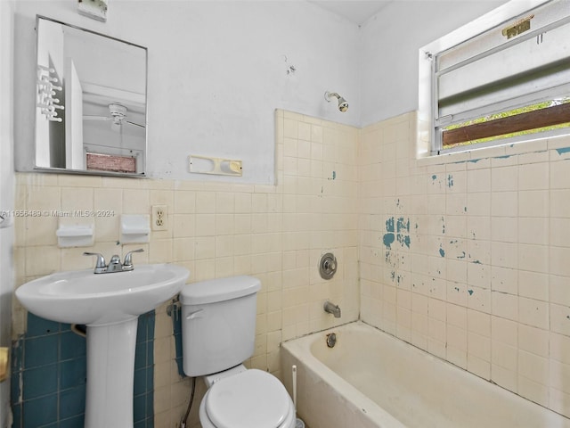 full bathroom featuring a wainscoted wall, toilet, tile walls, and a sink