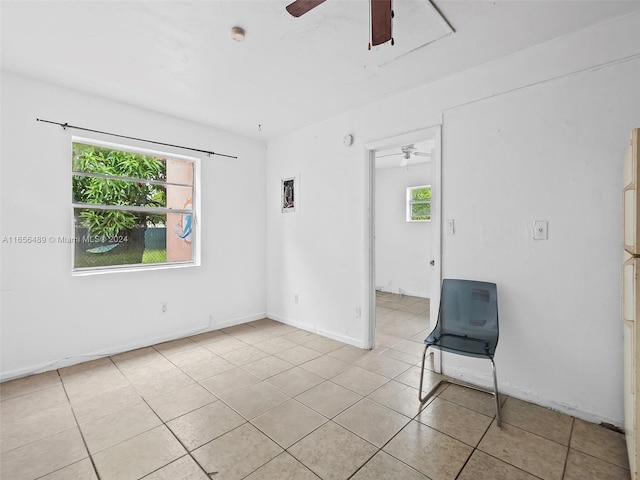 empty room with ceiling fan and light tile patterned floors