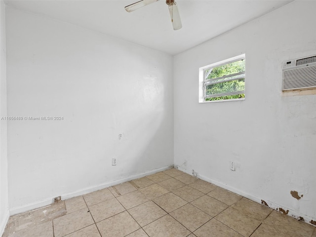 spare room with baseboards, an AC wall unit, and a ceiling fan