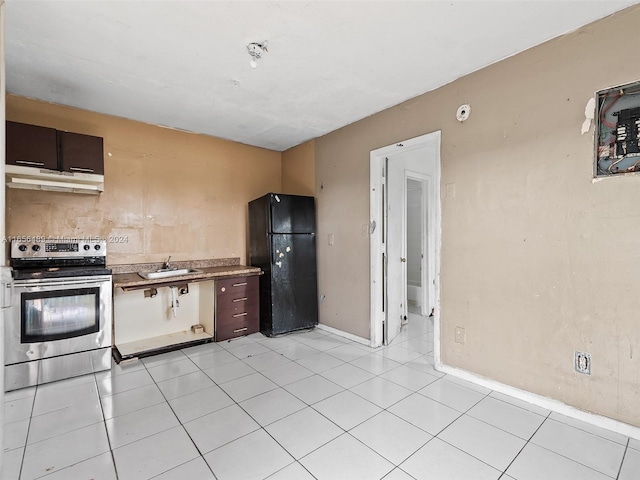 kitchen featuring stainless steel electric range oven, sink, dark brown cabinets, light tile patterned flooring, and black fridge