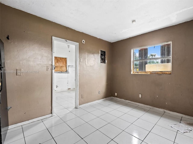 unfurnished room with light tile patterned floors and baseboards