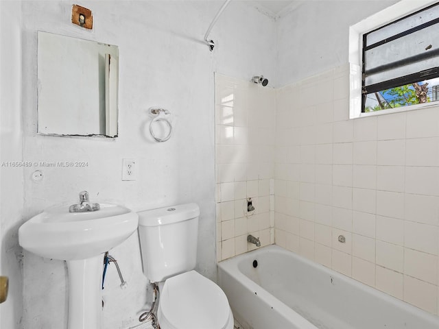 bathroom with toilet and tiled shower / bath combo