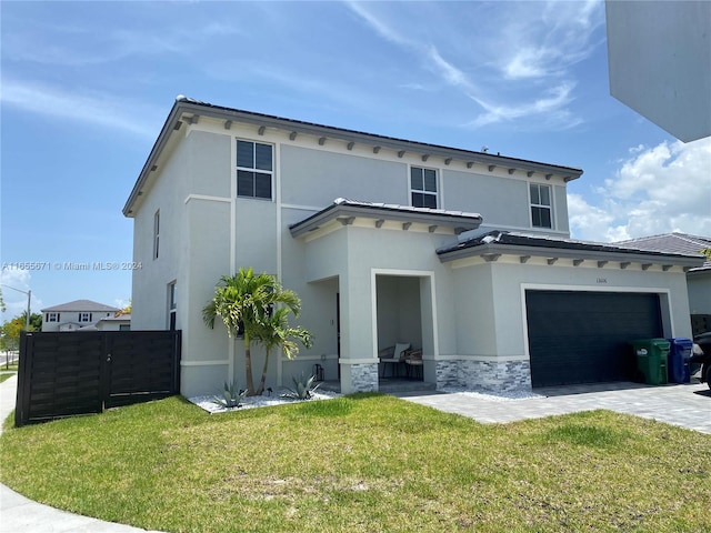 mediterranean / spanish house featuring a garage and a front yard