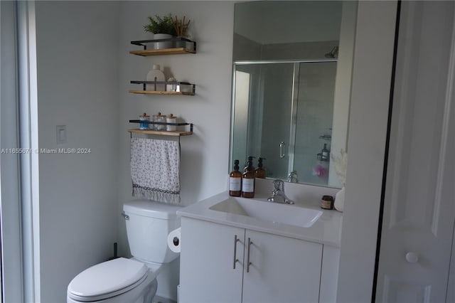 bathroom featuring vanity, toilet, and an enclosed shower