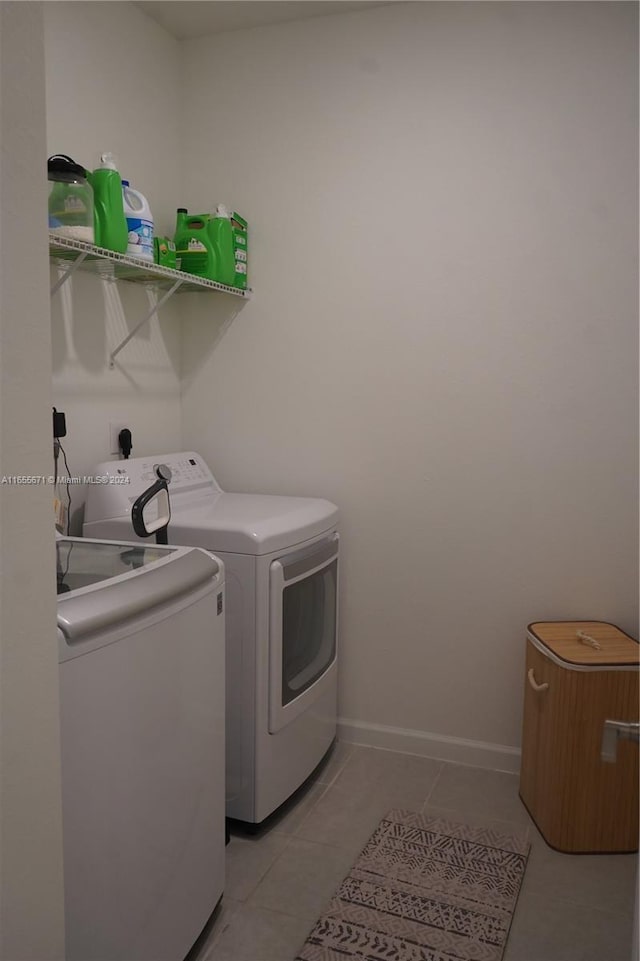 laundry room with light tile patterned floors and washing machine and dryer