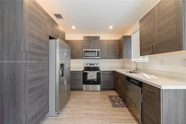 kitchen with light hardwood / wood-style flooring, stainless steel appliances, and sink