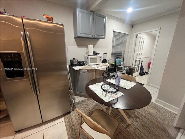 kitchen with gray cabinets, light tile patterned flooring, and stainless steel fridge